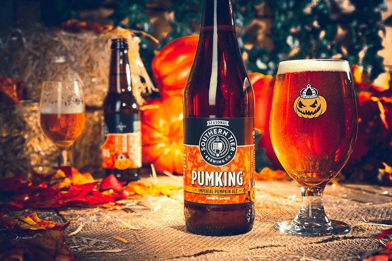 Southern Tier Pumking bottles and drinks in glasses with pumpkins and hay in the background.
