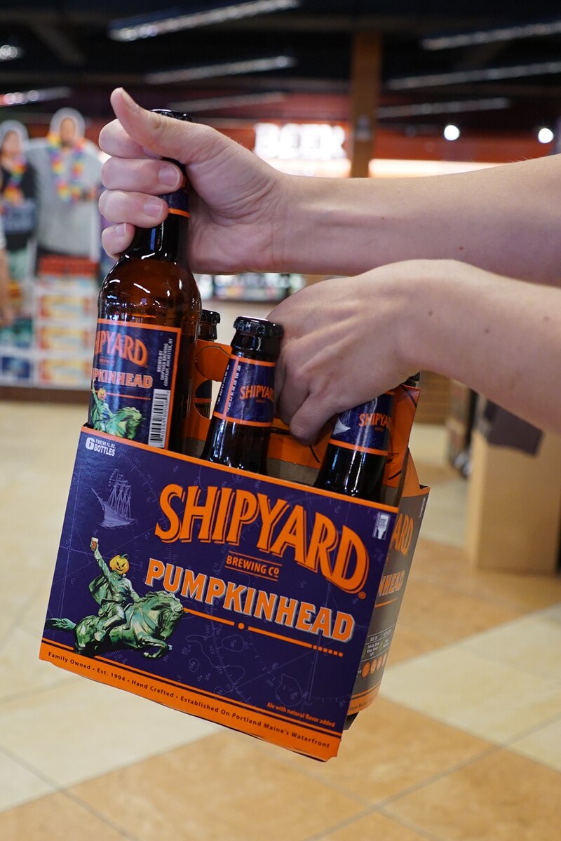 Someone holding a Shipyard Pumpkinhead 6pk bottle.