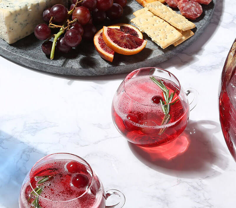 Glasses of Pinnacle Holiday Cranberry Punch next to a charcuterie board.