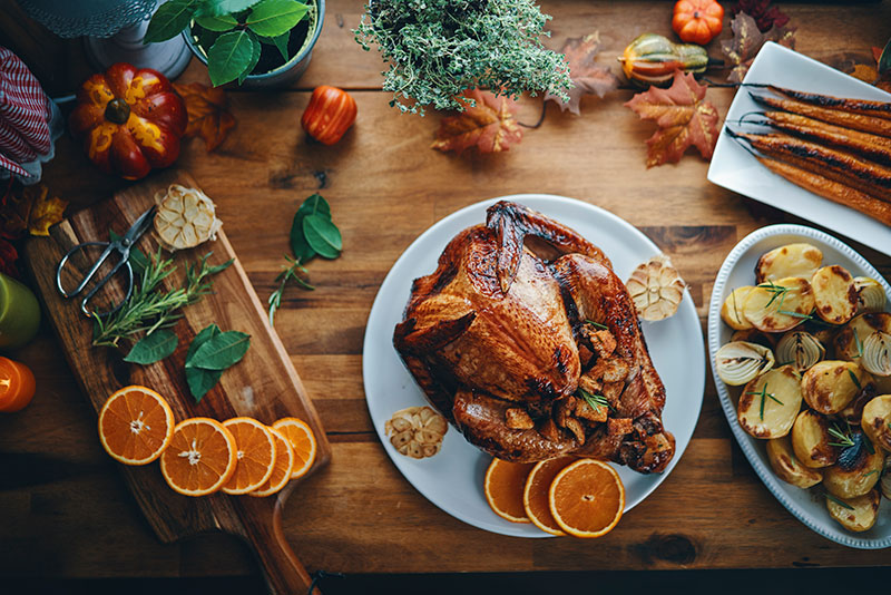 Beer-brined turkey resting next to Thanksgiving dinner sides. 